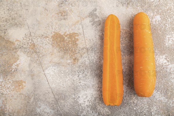 Orange Carrot on brown concrete background. Top view, copy space, flat lay. healthy food, vegetable, minimalism