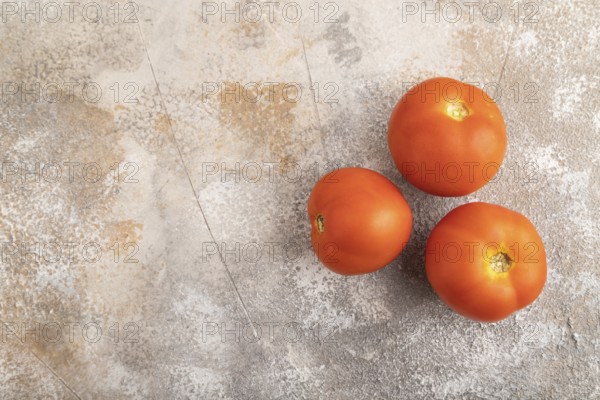 Red tomato on brown concrete background. Top view, flat lay, copy space. healthy food, vegetable, minimalism