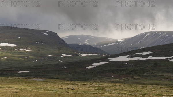 Lonely plateau with snowfields, low clouds, Kongevegen or King's Road, Olavsleden pilgrimage route, Dovrefjell, Oppdal municipality, Trøndelag county, Norway