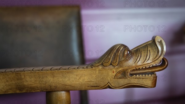 Detailreiche Schnitzerei eines Drachenkopfes an der Armlehne eines Holzstuhls, historischer Bauernhof und Pilgerunterkunft Budsjord, Dovre, Pilgerweg Olavsweg oder Olavsleden, Gudbrandsdalen oder Gudbrandstal, Norwegen