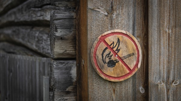 Runde Holztafel mit aufgemaltem Verbotssymbol gegen das Entfachen von Feuer, historischer Bauernhof und Pilgerunterkunft Budsjord, Dovre, Pilgerweg Olavsweg oder Olavsleden, Gudbrandsdalen oder Gudbrandstal, Norwegen