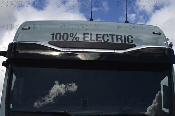 A sign on an electric lorry states that the vehicle is 100 percent electrically powered. The vehicle is parked on the premises of the Enegie-Mann company in Westerwald