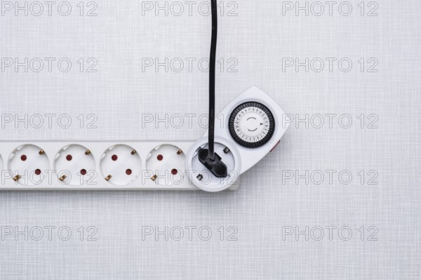 Top shot of a timer in a power strip on a white Resopal panel