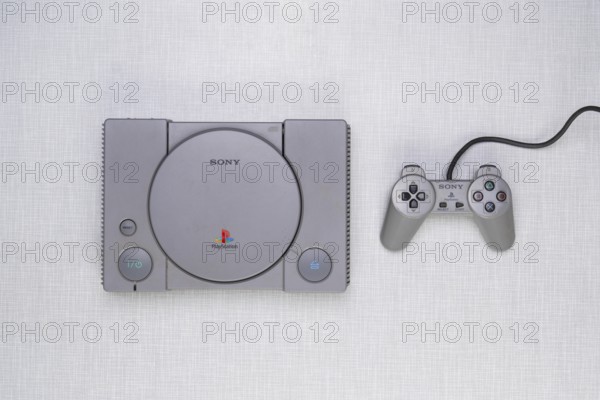 Top shot of a Playstation 1 with controller on a white Resopal board