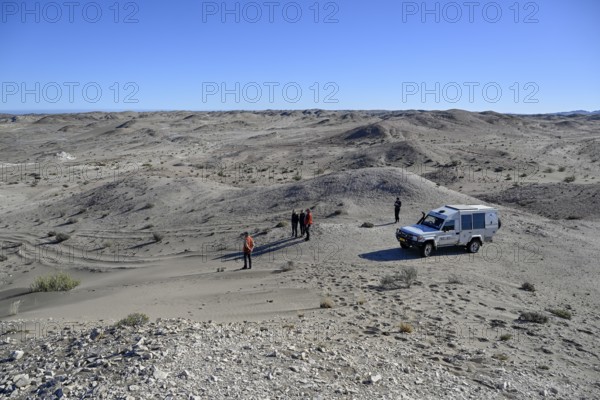 Touristengruppe in der Wüstenlandschaft bei Pomona, Diamentensperrgebiet, bei Lüderitz, Region Karas, Namibia