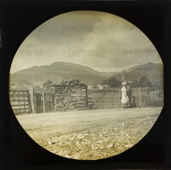 Woman Victorian or Edwardian tourist with background of Ambleside, Lake District, Cumbria, England, UK c 1900
