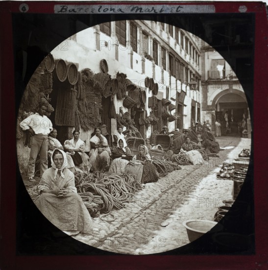 'Espartería en Almería' 1890 photographers Hermenegildo Otero and Miguel Aguirre, circular magic lantern slide mis-captioned as Barcelona, Spain. Women basket weavers and rope makers sitting in market place. Thought to be Cordoba