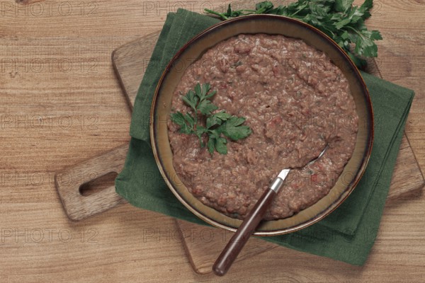 Red bean lobio, a traditional Georgian dish, on a wooden table, homemade