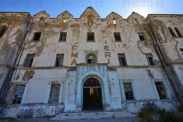 Lost Place, Verfallene Fassade eines Gebäudes mit verblassender Schrift und architektonischen Details, Caserma Avieri, Gefängnis, Konzentrationslager, Psychiatrische Klinik, Irrenanstalt, Lakki, Leros, Dodekanes, Griechische Inseln, Griechenland
