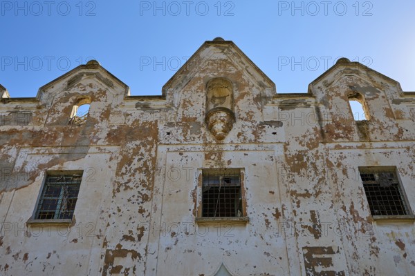 Lost Place, Verfallene Fassade eines alten Gebäudes vor klarem Himmel, Caserma Avieri, Gefängnis, Konzentrationslager, Psychiatrische Klinik, Irrenanstalt, Lakki, Leros, Dodekanes, Griechische Inseln, Griechenland