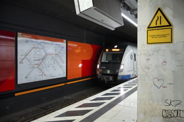 Schild Gefahrenzone, verengter Bahnsteigbereich, hier kein Aufenthalt, unterirdisch einfahrende S-Bahn, Zug, Baureihe 420 Generation 2025, Bahnsteig, Haltestelle, Bahnhof Hauptbahnhof, Graffiti, Streckenplan, ÖPNV, Nahverkehr, Bewegungseffekt, Stuttgart, Baden-Württemberg, Deutschland