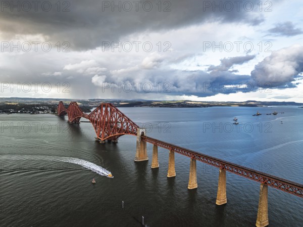 Rain clouds over Forth Bridge from a drone, Queensferry Crossing, Forth Estuary, Scotland, United Kingdom