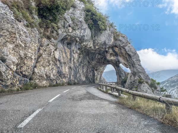 View from moving car on double rock arch rock gate Arches de Gréolières in on the Route de Gentelly D2 rock formation with passage on road Route de Gentelly, Greolieres, Département Alpes-Maritimes, Region Provence-Alpes-Côte d'Azur, France