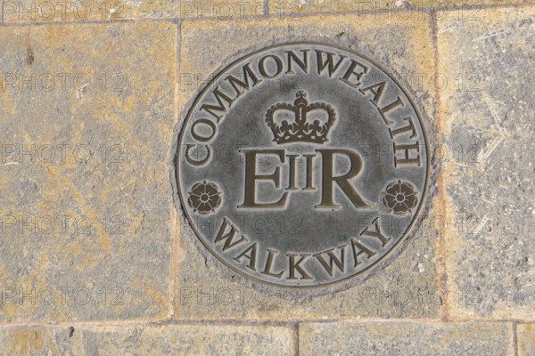 Large round plaque in plate from pedestrian zone in Valletta capital of Malta floor plaque with inscription Commonwealth Walkway and stylised British crown below E II R for Ween Elizabeth II Regina English Queen Elizabeth II, Valletta, Malta