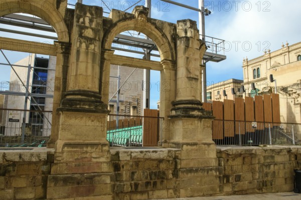 View through former arched window of ruins of former opera house Royal Opera House of Valletta destroyed in World War II on seating of integrated open-air stage, Valletta, Malta