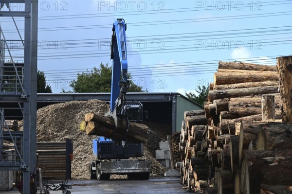 Wood storage and mechanical log transport on the premises of Energie-Mann in the Westerwald. Wood pellets are produced there