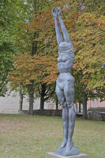 Sculpture Große Neeberger Figur von Wieland Förster 1997, nude standing female figure, nude, undress, undressing, clothes, over, head, covered, up, without, arms, high, up, stretching, bronze sculpture, modern art, sculpture park, Magdeburg, Saxony-Anhalt, Germany