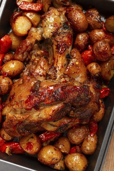 Pork knuckle, baked with vegetables, new potatoes, on a baking sheet, homemade, no people