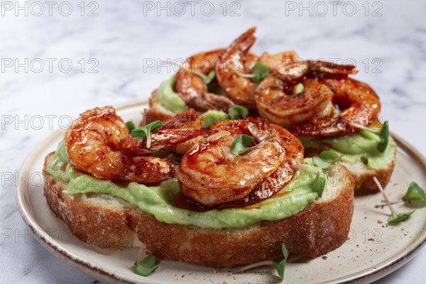 Sandwiches with avocado and caramelized shrimp, micro-greens, breakfast, on a plate, top view, homemade, no people