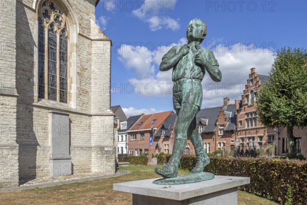 Statue Anzie Seppe, chiro boy in front of the Sint-Petruskerk, Saint Peter's Church in the village Bazel near Kruibeke, East Flanders, Belgium