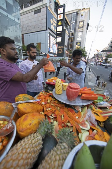 Indian men buying fresh fruit at a roadside stall, Begaluru or Bangalore, Karnataka, India