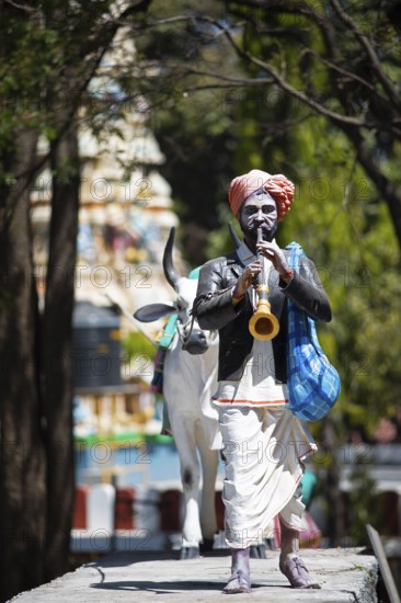 Statue of a farmer playing the shenai or traditional flute at the Hindu Basavanagudi Bull Temple, Begaluru or Bangalore, Karnataka, India