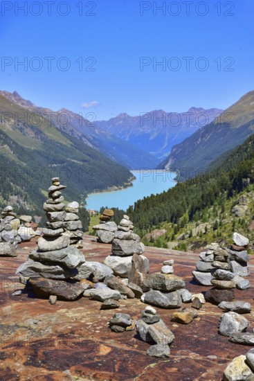 Hiking area below the Gepatsch Glacier in the Kaunertal with red rocks and the Kaunertal reservoir in the background, Ötztal Alps, Tyrol, Austria
