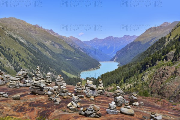 Hiking area below the Gepatsch Glacier in the Kaunertal with red rocks and the Kaunertal reservoir in the background, Ötztal Alps, Tyrol, Austria
