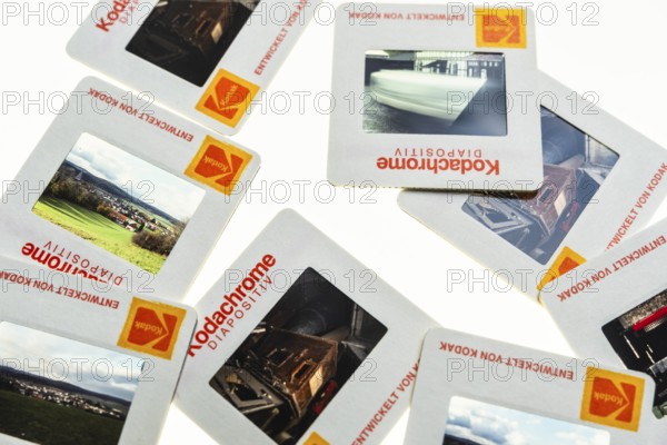 Many framed Kodachrome slides on a light table with magnifying glass, top shot