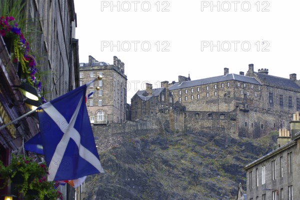 Scottish castle on a hill surrounded by buildings and a Scottish flag, Old Town, Edinburgh, Scotland, United Kingdom