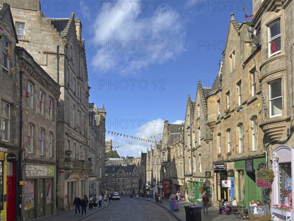 Historic street lined with old buildings under a clear sky, Old Town, Edinburgh, Scotland, United Kingdom
