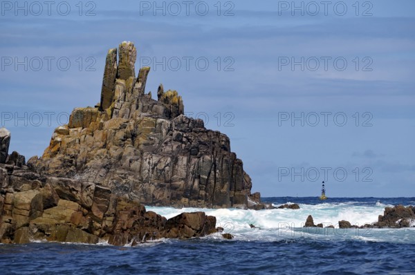 Coastal landscape with imposing cliffs and rough seas under a blue sky, Isles of Scilly, Cornwall, Great Britain