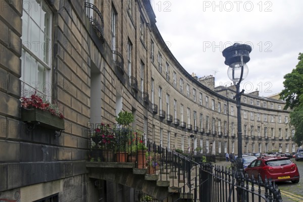 Historic street scene with buildings in a semicircle, flowers and a car, New Town, Edinburgh, Scotland, United Kingdom