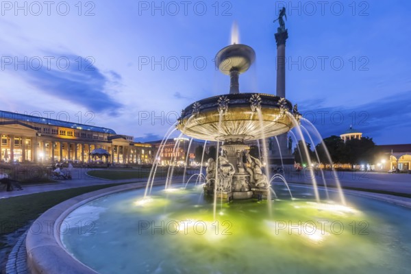 Evening atmosphere at Schlossplatz Stuttgart. View of the Königstraße pedestrian zone and the Königsbau. Illuminated fountain bowl at the fountain. Stuttgart, Baden-Württemberg, Germany