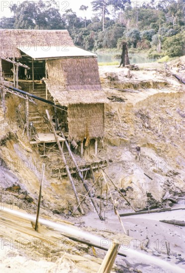 Open Cast gravel-pumping tin mine Malaya, Malaysia, south east Asia 1964 - pumping raises the slurry from the sump to an elevated wooden sluice level called a palong