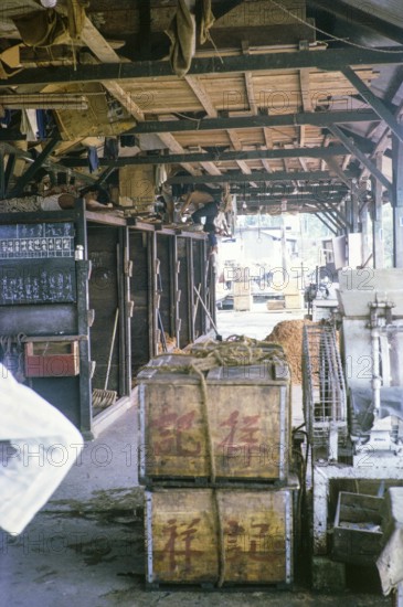 Siesta on the ice store ice at the fish market, East coast, Mersing, Johor, Malaya, Malaysia, south east Asia 1964