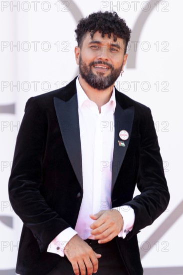 Venice, Italy - 3 September 2025: Amine Bouhafa wears a sticker in the colours of the Palestine flag and a sticker with the inscription - enough - on his jacket during the red carpet of - The Voice Of Hind Rajab - during the 82nd Venice International Film Festival