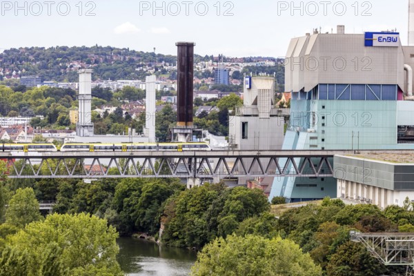 SWEG regional train travelling on the Schusterbahn, Münster viaduct over the Neckar with EnBW Energie Baden-Württemberg combined heat and power plant. Stuttgart, Baden-Württemberg, Germany