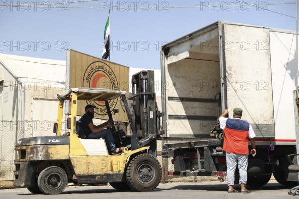 Relief workers unload boxes of medical aid provided by Qatar at Damascus International Airport, part of the humanitarian bridge supporting Syria's recovery and reconstruction after the fall of Bashar al-Assad, Damascus, Damascus, Syria