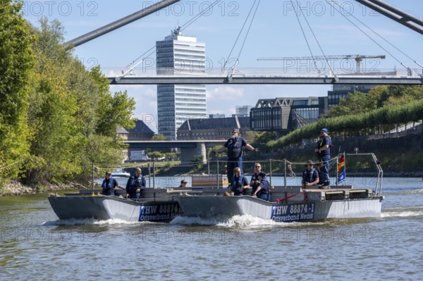 Exercise run of a multi-purpose pontoon on the Rhine, Medienhafen, the skipper gives instructions to the two helmsmen by hand signal, the specialist group for water hazards, in Düsseldorf, the motorised pontoon can be used as a ferry for people or equipment, as a working platform or bridge, during the major exercise FÜLEX25, lasting several days, of the THW, Technisches Hilfswerk, Landesverband North Rhine-Westphalia, over 3500 volunteers from the 127 North Rhine-Westphalia local associations practise many different scenarios over 4 weekends