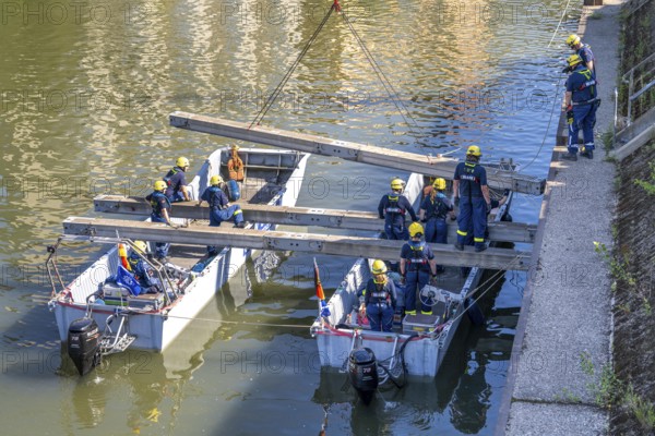 Construction of a multi-purpose pontoon, the specialist group for water hazards, in Düsseldorf, the motorised pontoon can be used as a ferry for people or equipment, as a working platform or bridge, during the major exercise FÜLEX25, lasting several days, of the THW, Technisches Hilfswerk, Landesverband North Rhine-Westphalia, over 3500 volunteers from the 127 North Rhine-Westphalia local associations practise many different deployment scenarios over 4 weekends