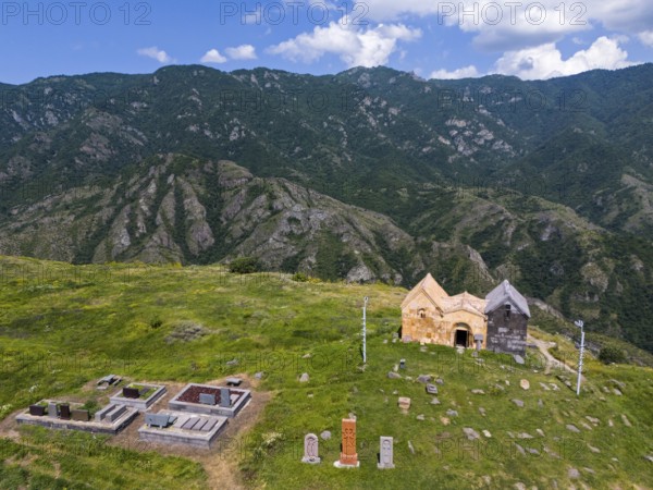 Old church and cemetery on a green mountain under a blue sky with clouds, aerial view, landscape near Odsun, Odzun, Saint Nshan Church, Debed Gorge, Lorikeet Province, Armenia