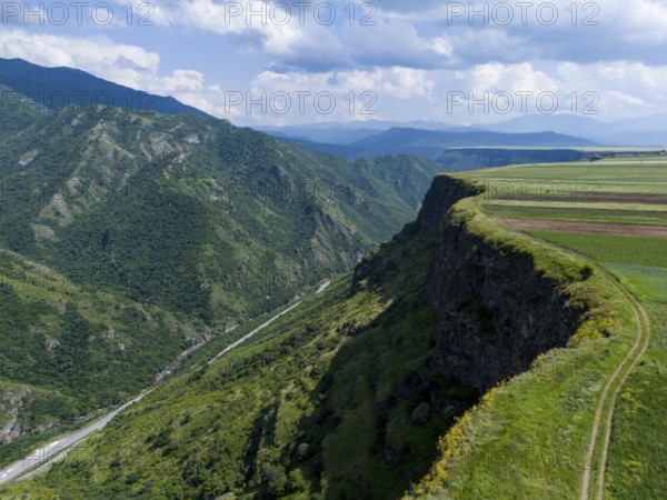 Steep slope with a view of the wide valley and patterned fields under a blue sky, aerial view, landscape near Odsun, Odzun, Debed Gorge, Lorikeet Province, Armenia