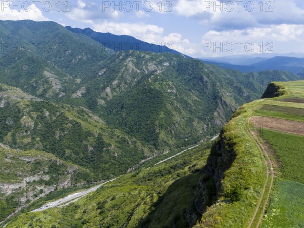Landscape with gorge and mountain range, flanked by fields under cloudy sky, aerial view, landscape near Odsun, Odzun, Debed Gorge, Lorikeet Province, Armenia
