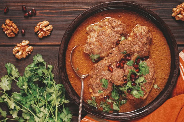 Fesenjan, an Iranian dish, stewed chicken, in walnut-pomegranate sauce, in an earthen pan, homemade, no people