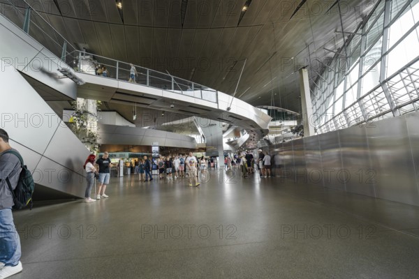 Large interior with modern architecture and people walking through the space, BMW Welt, Munich, Germany