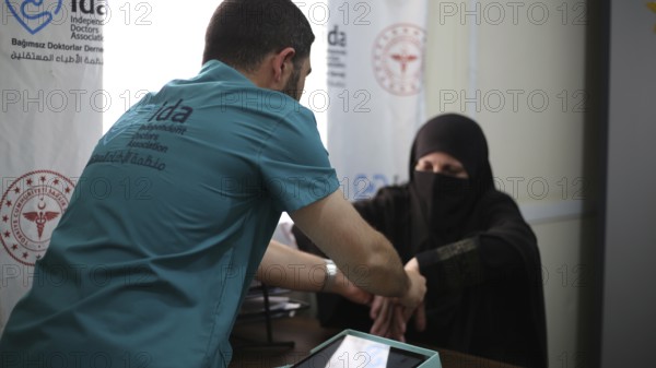 A doctor examining a woman inside a mobile medical point dedicated to treating Syrian refugees. Aleppo, Syria May 28, 2022, Aleppo, Syria