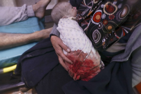 A frightened mother carries her infant after he was pulled from the rubble of a deadly earthquake that struck Turkey and Syria, leaving tens of thousands dead. Aleppo, Syria – Feb 6, 2023, aleppo, syria