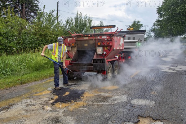 Glendora, Michigan - A worker for the Berrien County Road Department patches potholes on Wagner Road