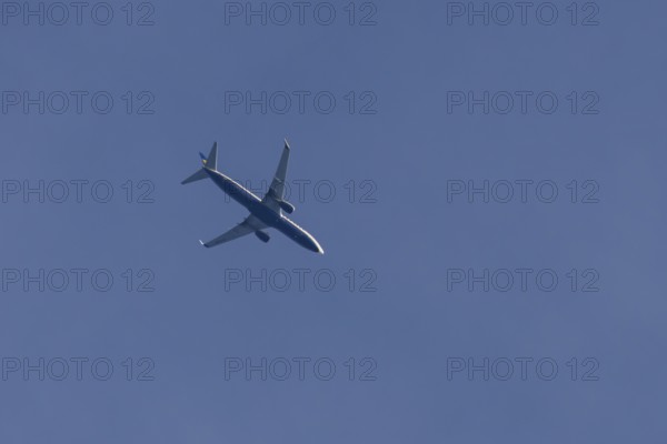 Boeing 737 jet passenger aircraft of Ryanair airlines flying in a blue sky, England, United Kingdom